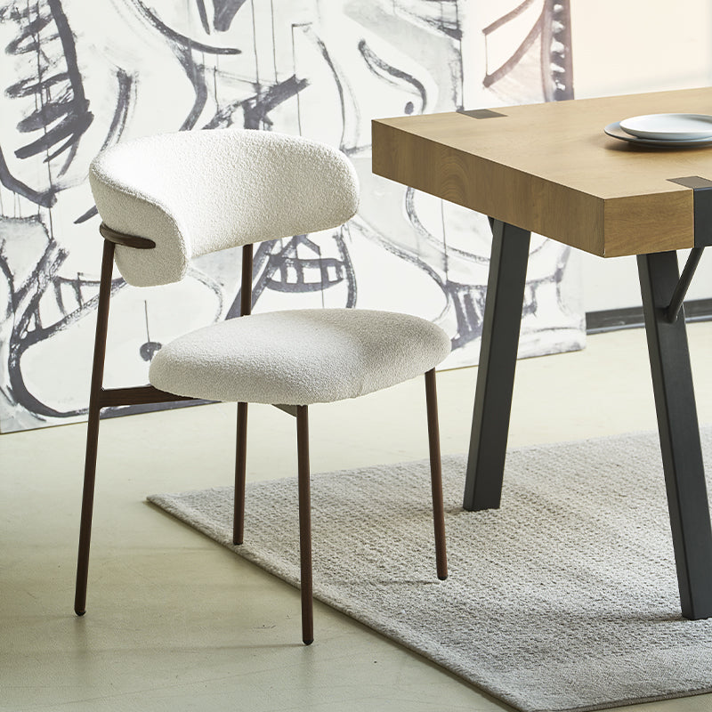 Sedia da pranzo Zahra in bouclé beige accanto a un tavolo in legno chiaro, stile scandinavo