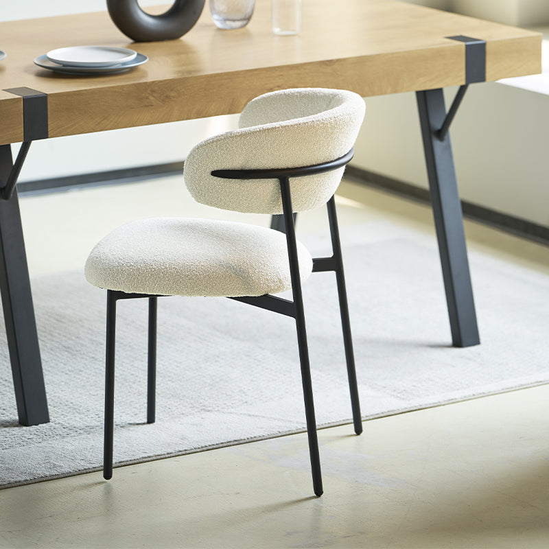 Sedia da pranzo Zahra in bouclé beige accanto a un tavolo in legno chiaro, stile scandinavo