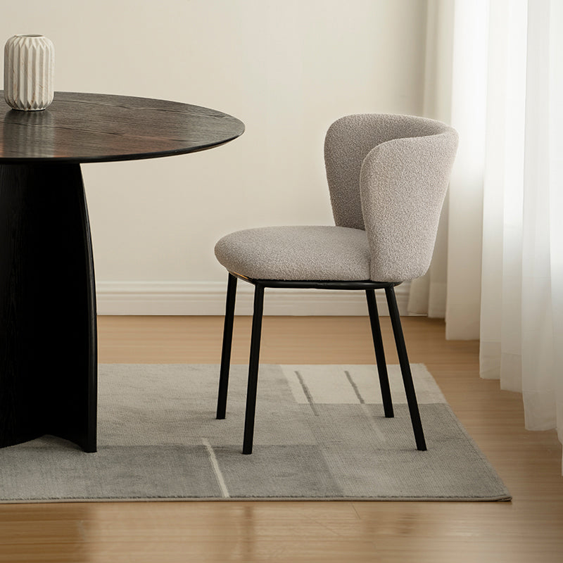Sedia da pranzo Karin in tessuto bouclé beige con schienale alto e gambe in metallo nero. Perfetta per sale da pranzo o home office. OFCASA.