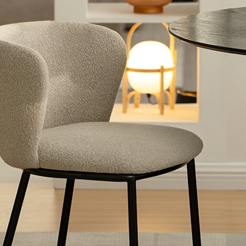 Sedia da pranzo Karin in tessuto bouclé beige con schienale alto e gambe in metallo nero. Perfetta per sale da pranzo o home office. OFCASA.