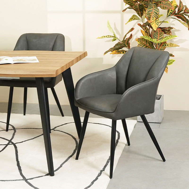 Quattro sedie da pranzo Sienna grigie con rivestimento in tessuto e gambe in metallo nero, posizionate intorno a un tavolo in legno，Sedia Sienna in primo piano che mostra lo schienale ergonomico e l'imbottitura premium, perfetta per pranzi prolungati