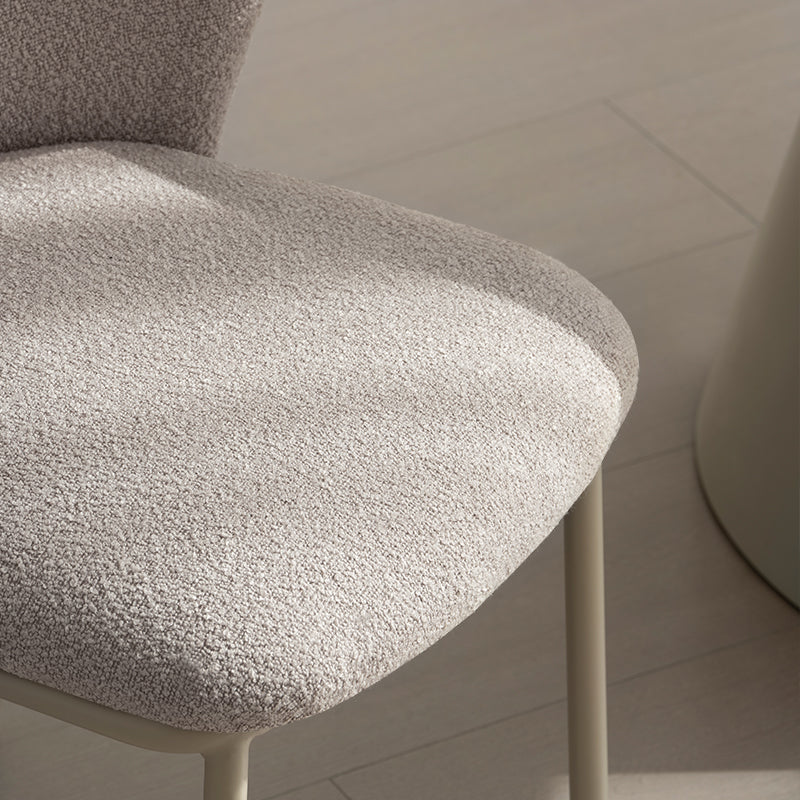 Sedia da pranzo Karin in tessuto bouclé beige con schienale alto e gambe in metallo nero. Perfetta per sale da pranzo o home office. OFCASA.