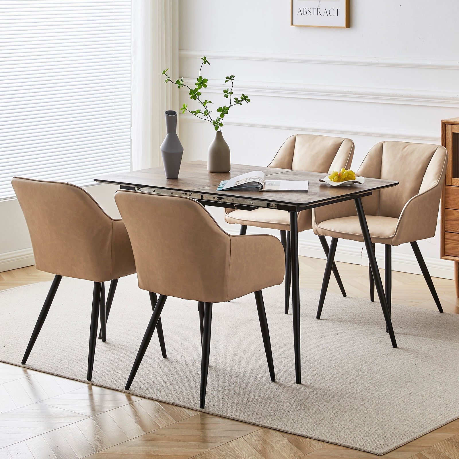 Quattro sedie da pranzo Sienna grigie con rivestimento in tessuto e gambe in metallo nero, posizionate intorno a un tavolo in legno，Sedia Sienna in primo piano che mostra lo schienale ergonomico e l'imbottitura premium, perfetta per pranzi prolungati