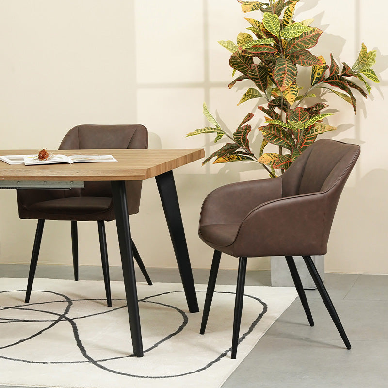 Quattro sedie da pranzo Sienna grigie con rivestimento in tessuto e gambe in metallo nero, posizionate intorno a un tavolo in legno，Sedia Sienna in primo piano che mostra lo schienale ergonomico e l'imbottitura premium, perfetta per pranzi prolungati