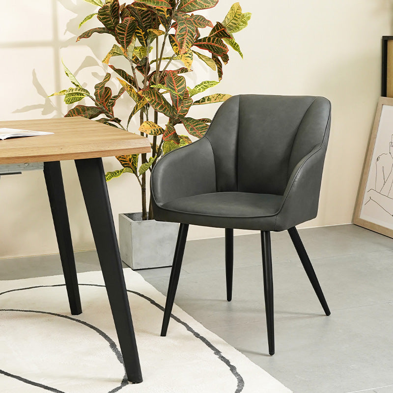 Quattro sedie da pranzo Sienna grigie con rivestimento in tessuto e gambe in metallo nero, posizionate intorno a un tavolo in legno，Sedia Sienna in primo piano che mostra lo schienale ergonomico e l'imbottitura premium, perfetta per pranzi prolungati